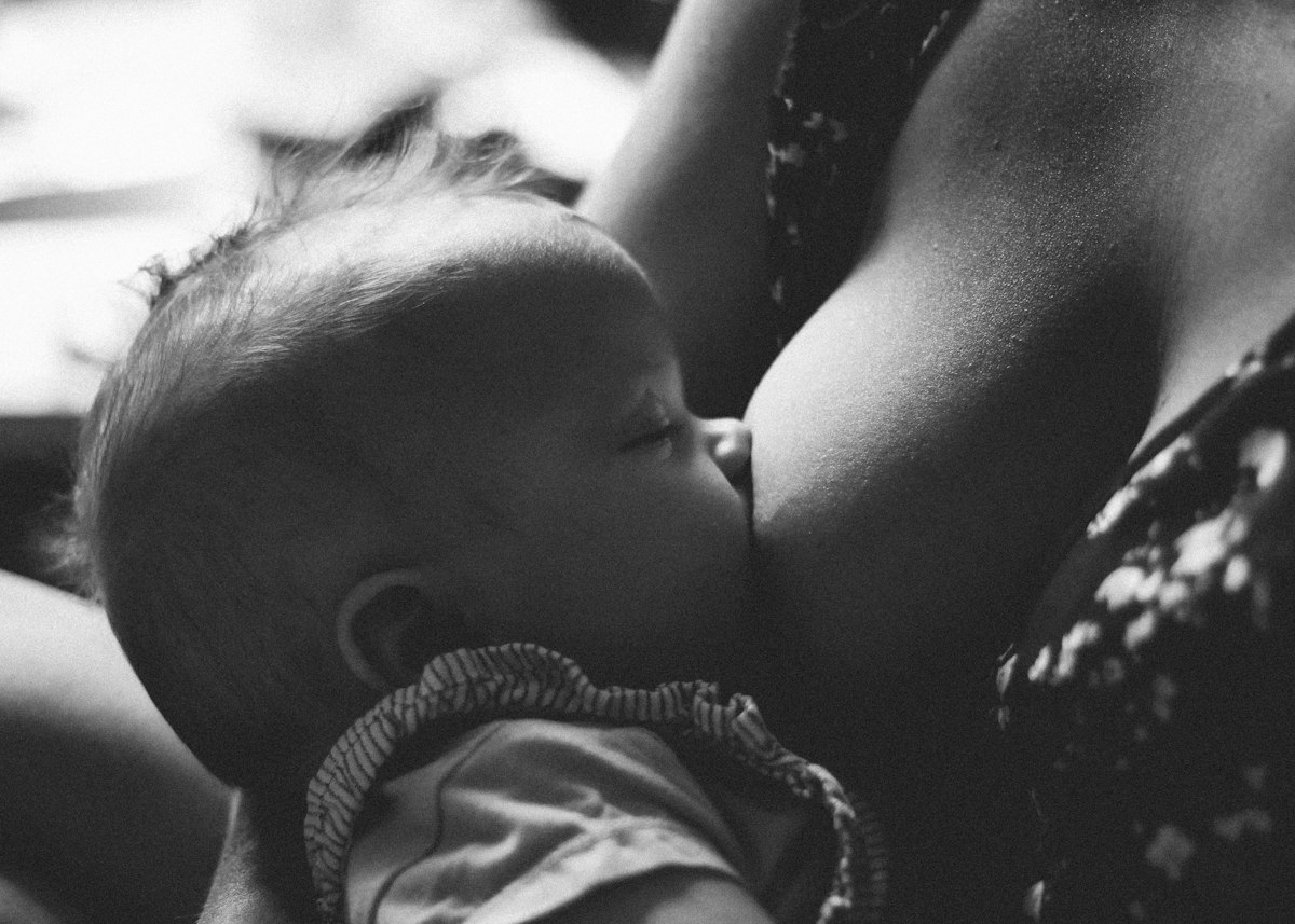 Schwarz-Weiß-Foto: Ein Baby wird von seiner Mutter gestillt